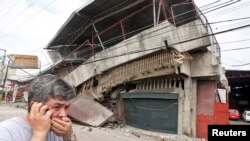 Un residente pasa frente a una casa colapsada durante un terremoto en la ciudad de Cebu, en el centro de las Filipinas.
