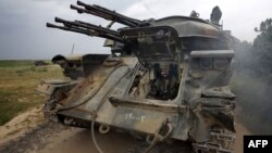 Syrian soldier sits inside a tank as troops take control of the village of Western Dumayna, some seven kilometers north of the rebel-held city of Qusayr, May 13, 2013. 