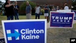 FILE - In this Oct. 27, 2016 file photo, early voters stand by campaign signs at a voting location in Dallas. Campaign signs have been a thing since the early 1800s.