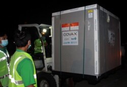 Petugas membongkar kotak vaksin COVID-19 AstraZeneca yang tiba di Bandara Internasional Soekarno-Hatta di Tangerang, pinggiran Jakarta, 8 Maret 2021. (Muhammad Iqbal / Antara Foto via REUTERS)