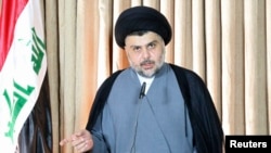 FILE - Iraqi Shi'ite cleric Moqtada al-Sadr delivers a speech in Najaf, Iraq, June 25, 2014. In what appears to be a departure from the traditional Shi'ite position, Al-Sadr has called on Syria's President Bashar al-Assad to resign.