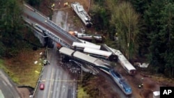 Cars from an Amtrak train that derailed above lie spilled onto Interstate 5, Dec. 18, 2017, in DuPont, Wash.