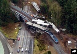 Cars from an Amtrak train that derailed above lie spilled onto Interstate 5, Dec. 18, 2017, in DuPont, Wash.