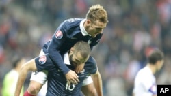 Antoine Grieazamnn de la France grimpe sur le dos de son co-équipier Karim Benzema après le but de ce dernier lors du match amical contre l’Argentine à Nice, France, 8 octobre 2015. 