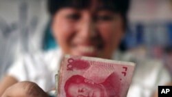 A bookstore vendor counts Chinese renminbi notes in Chengdu in southwest China's Sichuan province, (File)