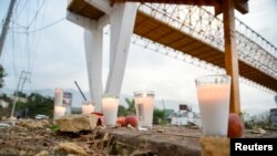 Votive candles are pictured at the site of a truck accident in Tuxtla Gutierrez