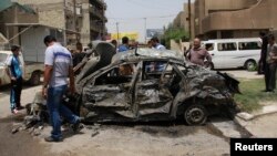 Residents gather at the site of a car bomb attack in Baghdad, May 30, 2013. 