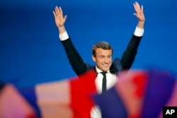ຜູ້ສະໝັກແຂ່ງຂັນເປັນປະທານາທິບໍດີ ຂອງຝຣັ່ງ ຫົວນິຍົມແນວທາງປານກາງ ທ່ານ Emmanuel Macron ໂບກມື ກ່ອນໜ້າການກ່າວຄຳປາໄສ ຕໍ່ບັນດາຜູ້ສະໜັບສະໜູນຂອງທ່ານ ຢູ່ທີ່ສຳນັກງານໃຫຍ່ຂອງທ່ານ ໃນວັນການເລືອກຕັ້ງ ທີ່ນະຄອນຫຼວງປາຣີ ຂອງຝຣັ່ງ, ວັນທີ 23 ເມສາ 2017.