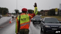 FILE - A Military Police officer gestures while checking the travel permits of motorists at a check point during the first day of the state of emergency in Gaborone, Botswana, Apr. 3, 2020. 