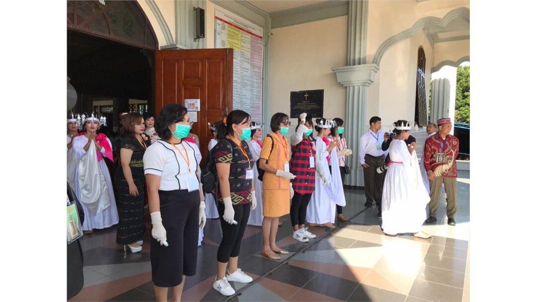 Para petugas gereja bersiap memeriksa suhu tubuh kepada umat yang hendak memasuki gedung gereja Katedral Ruteng, Nusa Tenggara Timur pada saat upacara penahbisan Uskup Ruteng, Kamis, 19 Maret 2020. (Foto: Pastor Steven Lalu)