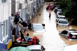 Tim SAR mengevakuasi warga dengan perahu dari daerah banjir akibat hujan deras di Daejeon, Korea Selatan, Kamis, 30 Juli 2020. (Kang Jong-min / Newsis via AP)