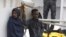 Migrants stand aboard the Italian Coast Guard ship Diciotti, moored at the Catania harbor, Aug. 21, 2018. 