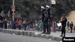 Riot police try to stop clashes and ask protesters, opposing Egyptian President Mohamed Mursi, to back away along Qasr Al Nil bridge, which leads to Tahrir Square in Cairo, Mar. 7, 2013. 