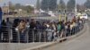 FILE - South African commuters line up at a bus stop in Soweto, May 17, 2010, during a strike by rail workers. Currently, a nationwide bus strike, in its fourth week, is causing similar lines to form for minibus taxis.