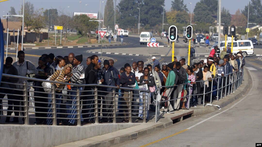 FILE - South African commuters line up at a bus stop in Soweto, May 17, 2010, during a strike by rail workers. Currently, a nationwide bus strike, in its fourth week, is causing similar lines to form for minibus taxis.