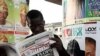 Nigerian man read a local newspapers with headlines, Independent National Electoral Commission flops, over a Portrait of Nigeria President Goodluck Jonathan in Lagos, April 3, 2011