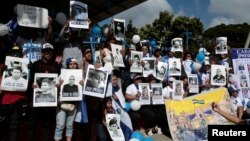 Nicaraguan expats living in Costa Rica hold pictures of people killed in riots or imprisoned as they take part in the "Caravan for Liberty and Justice" to protest against the government of Nicaraguan President Daniel Ortega, in La Cruz, Costa Rica, on the