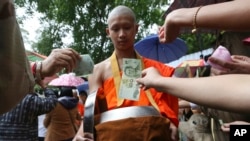 Followers offer banknotes to soccer team members as they are ordained as Buddhist monks and novices following their dramatic cave rescue last week in the Mae Sai district, Chiang Rai province, northern Thailand, July 25, 2018.