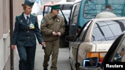 FILE - Ukrainian (L) and Polish border guards check passports during their joint work at a checkpoint at the Polish-Ukrainian border in Hrebenne, Apr. 18, 2012.