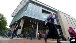 FILE - In this April 28, 2016, file photo, students walk by the James Branch Cabell Library on the campus of Virginia Commonwealth University in Richmond, Va.