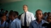 U.S. Secretary of Education Arne Duncan stands with students during his visit to Lycee de Petion-Ville high school in Petion-Ville, Haiti, Nov. 5, 2013. 