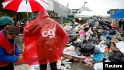 Striking French CGT labor union garbage collectors and sewer workers block access to a waste treatment plant to protest proposed labor reforms, in Ivry-sur-Seine, near Paris, France, May 31, 2016.