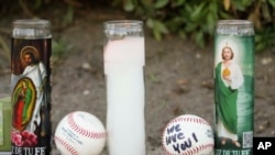 Candles and baseballs are placed outside Dodger Stadium after the death of former Dodgers pitcher Fernando Valenzuela, in Los Angeles, Oct. 23, 2024.