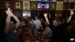 Mariella Roque, 21, of Miami, left, and Jorge Palamino, 24, of Miami, right, supporters of Republican presidential candidate Mitt Romney, cheer as they watch a televised debate between Romney and President Barack Obama in Coral Gables, Florida.