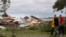 FILE - Members of a local Baptist Men's Association walk past a home that was destroyed after the remnants of tropical storm Beryl spun off a tornado that destroyed homes and damages dozens of others in the Pelletier community near Swansboro, NC on Wednesday, May 30, 2012.
