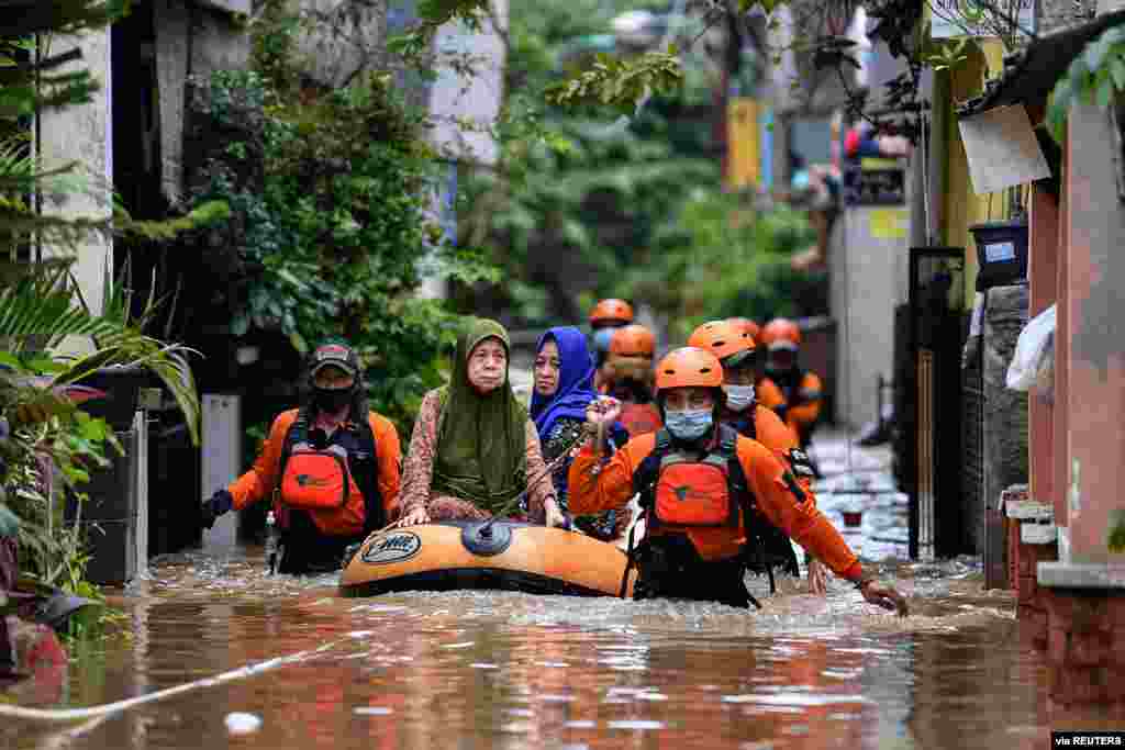 Volunteers evacuate elderly women with an inflatable boat in an area affected by floods, following heavy rains in Jakarta, Indonesia, in this photo taken by Antara Foto.