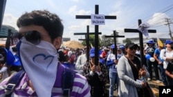 Anti-government protesters join a Stations of the Cross procession on Good Friday, carrying signs demanding the release of political prisoners in Managua, Nicaragua, April 19, 2019. 