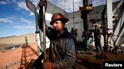 Roughneck Brian Waldner is covered in mud and oil while wrestling pipe on a True Company oil drilling rig outside Watford, North Dakota, October 20, 2012. Thousands of people have flooded into North Dakota to work in state's oil drilling boom. REUTERS/Jim