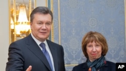Ukrainian President Viktor Yanukovych, left, greets EU foreign policy chief Catherine Ashton in Kiev, Ukraine, Tuesday, Dec. 10, 2013.