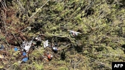 Foto difundida por la oficina de prensa de la Fuerza Aérea Colombiana muestra a equipos militares junto a restos de una aeronave que se estrelló en una zona rural de Urrao, departamento de Antioquia, Colombia, el 10 de enero de 2025. [Foto: AFP -Fuerza Aérea Colombia]