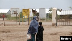 FILE - A mother and daughter walk at the Kakuma refugee camp in northern Kenya, March 5, 2018. 