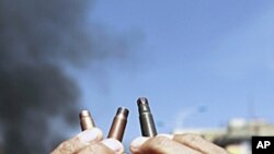 An anti-government protester displays spent bullet cases during a demonstration demanding the ouster of Yemen's President Ali Abdullah Saleh in the southern city of Taiz, May 11, 2011