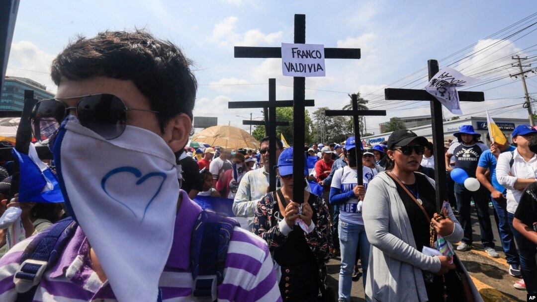 Anti-government protesters join a Stations of the Cross procession on Good Friday, carrying signs demanding the release of political prisoners in Managua, Nicaragua, April 19, 2019. 