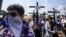 Anti-government protesters join a Stations of the Cross procession on Good Friday, carrying signs demanding the release of political prisoners in Managua, Nicaragua, April 19, 2019. 
