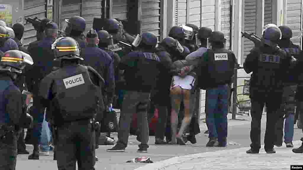 Un homme à moitié nu est emmené par les forces de sécurité lors de l&rsquo;assaut à Saint-Denis, 18 novembre 2015.