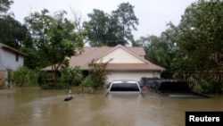 Casas y automóviles parcialmente sumergidos por las inundaciones causadas por la tormenta tropical Harvey en el este de Houston, Texas, EE.UU., el 28 de agosto de 2017.
