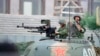 资料照：示威运动被镇压后，部署在北京东部某要道口的一辆坦克，一名坦克兵握着上了子弹的机枪，另一名坦克兵端着手枪。(1989年6月5日)