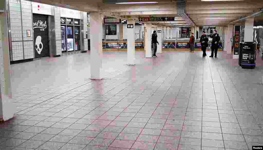 28일 뉴욕시 타임스퀘어 지하철역에서 마지막 점검을 하는 경찰. 뉴욕시는 29일 지하철을 운행하지 않았다.