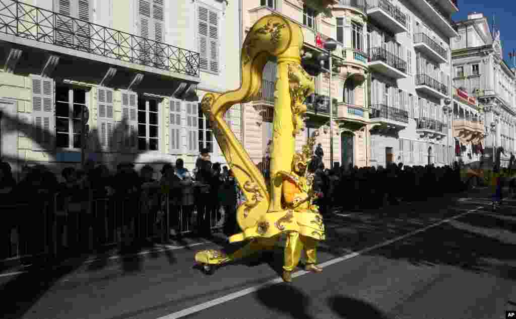 A reveler holding a giant harp, parades during the flower parade of the 131st Nice carnival edition in southern France. The Carnival, running from Feb. 13 until Mar. 1, 2015, celebrates the &quot;King of Music&quot;.