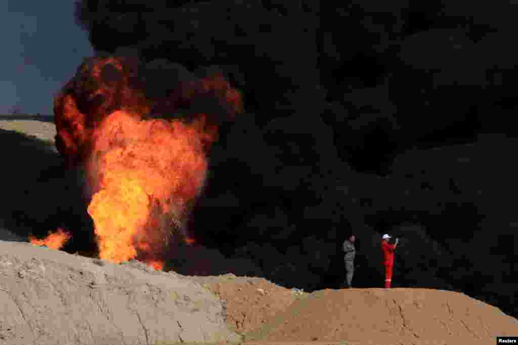Asap membumbung dari sumur minyak yang terbakar di Dibis, pinggiran Kirkuk, Irak.
