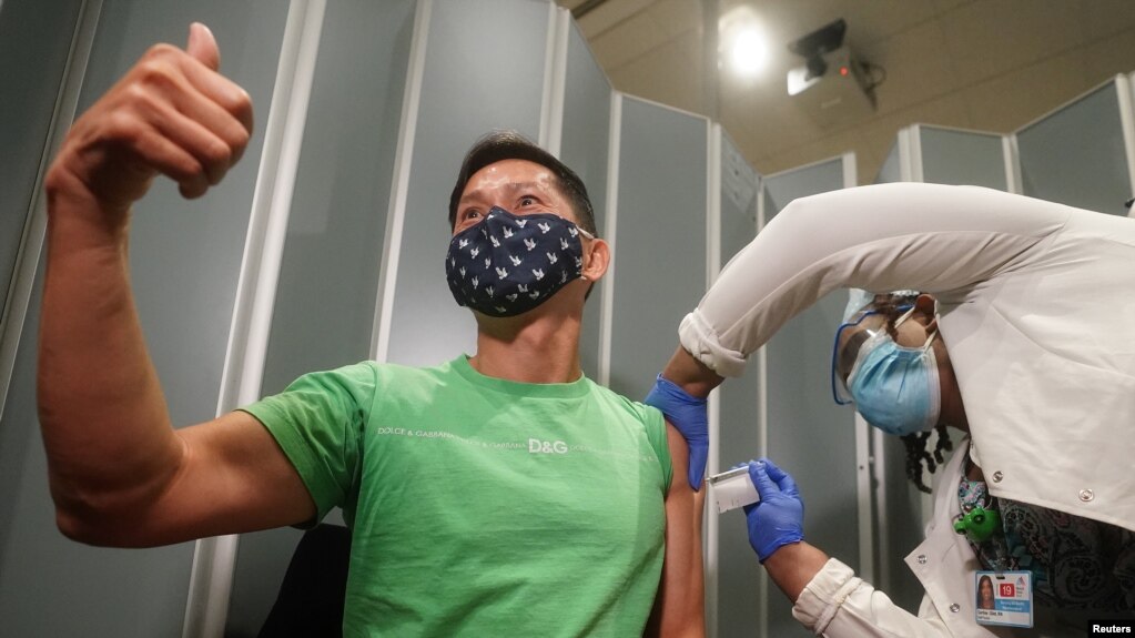 纽约市西奈山医院的Tommy Wong医生在接种辉瑞新冠病毒疫苗时伸出大拇指。（2020年12月15日）(photo:VOA)