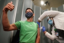 纽约市西奈山医院的Tommy Wong医生在接种辉瑞新冠病毒疫苗时伸出大拇指。（2020年12月15日）