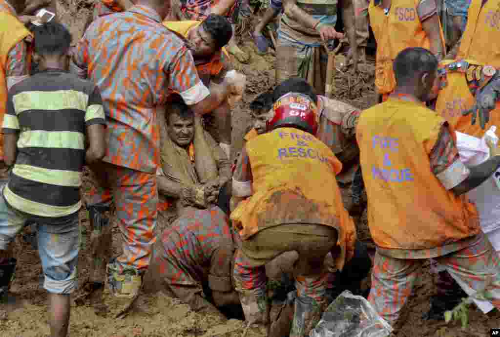 Rescuers pull out a dead body after a massive landslide in Rangamati district, Bangladesh. Rescuers struggled to reach villages hit by massive landslides that have killed more than 100 people, while also burying roads and cutting power in the southeastern part of the country, officials said.