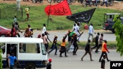Des membres du Mouvement islamique du Nigeria (IMN) agitent des drapeaux lors d'une manifestation pour protester contre l'emprisonnement d'un chiite à Abuja, le 29 octobre 2018.