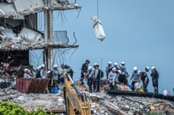 Tim SAR mencari kemungkinan korban selamat di gedung kondominium Champlain Towers South 12 lantai yang sebagian runtuh pada 30 Juni 2021 di Surfside, Florida. (Foto: AFP)