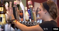 A bartender at Chris Tyll's restaurant pours a beer. Tyll does not think the government should require him to raise the wages of his employees.